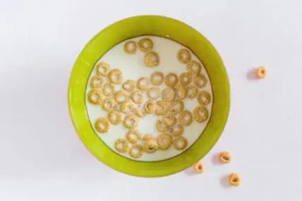 Image of a green bowl filled with Cheerios and milk, which may be contaminated with pesticides.