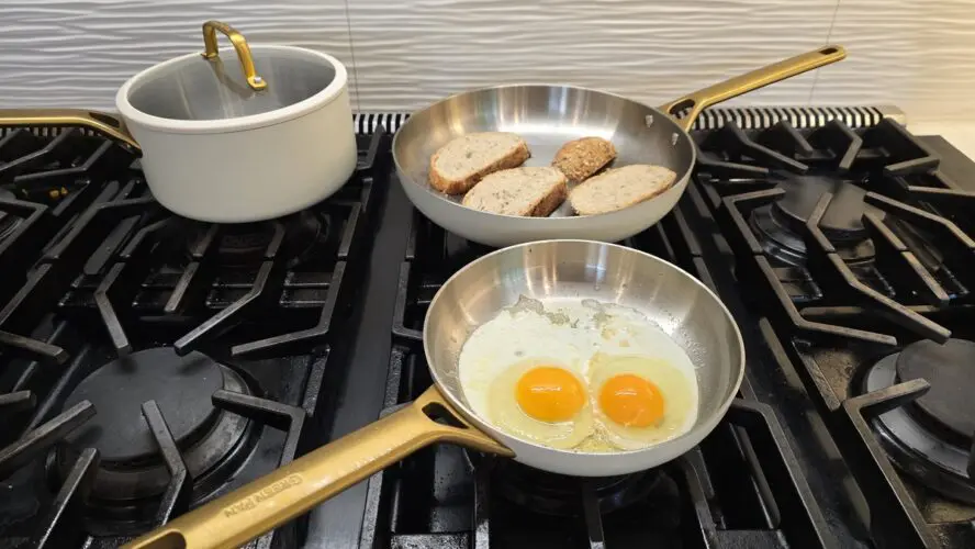 Image of the GreenPan Reserve Pro Stainless Steel set in cream in Laura Klein's kitchen, being used on the stovetop to make toast and eggs.