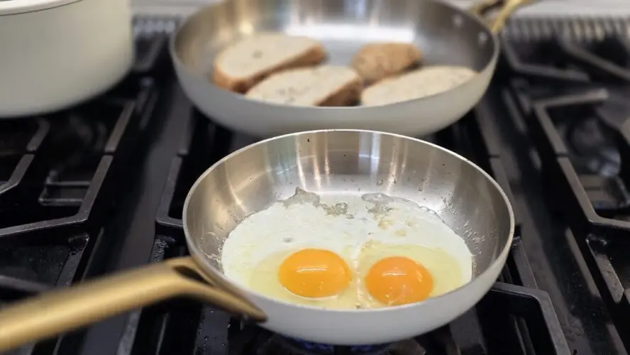 Image of two sunny-side up eggs in a GreenPan Reserve Pro Stainless Steel frypan on a stovetop.