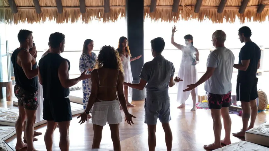 Image of a group of people stretching and holding their hands outstretched in a circle.