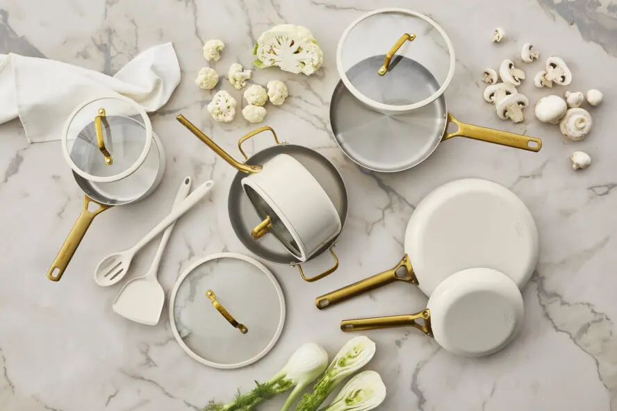 Image of various pieces in the GreenPan Reserve Pro Stainless Steel collection laid out on a marble tabletop.
