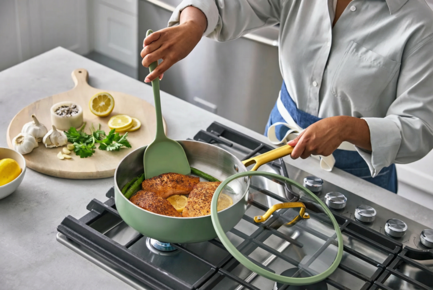 Image of the GreenPan Reserve Pro Stainless Steel sauté pan in Sage, with a spatula shown flipping seared fish.