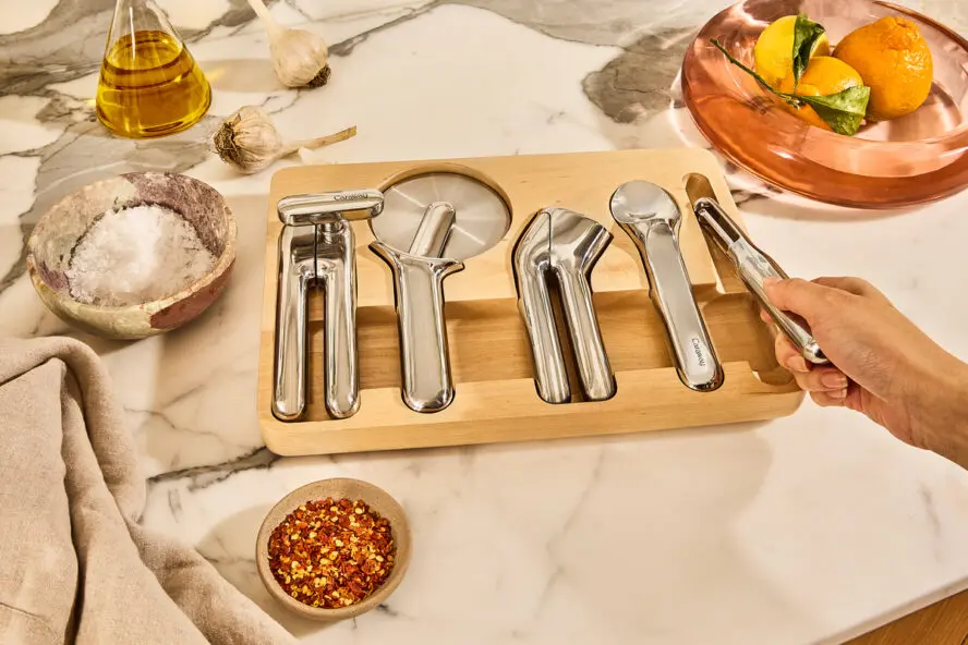 Image of the Caraway Kitchen Gadget Set in the included organizer shown on a beautiful marble countertop.