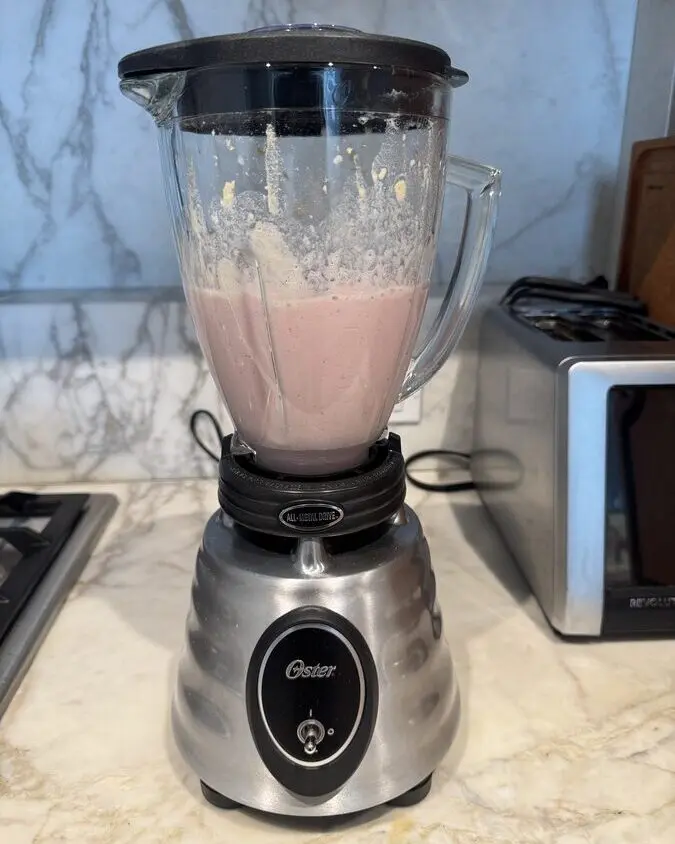Image of the Oster Heritage blender filled with a pink smoothie mixture.
