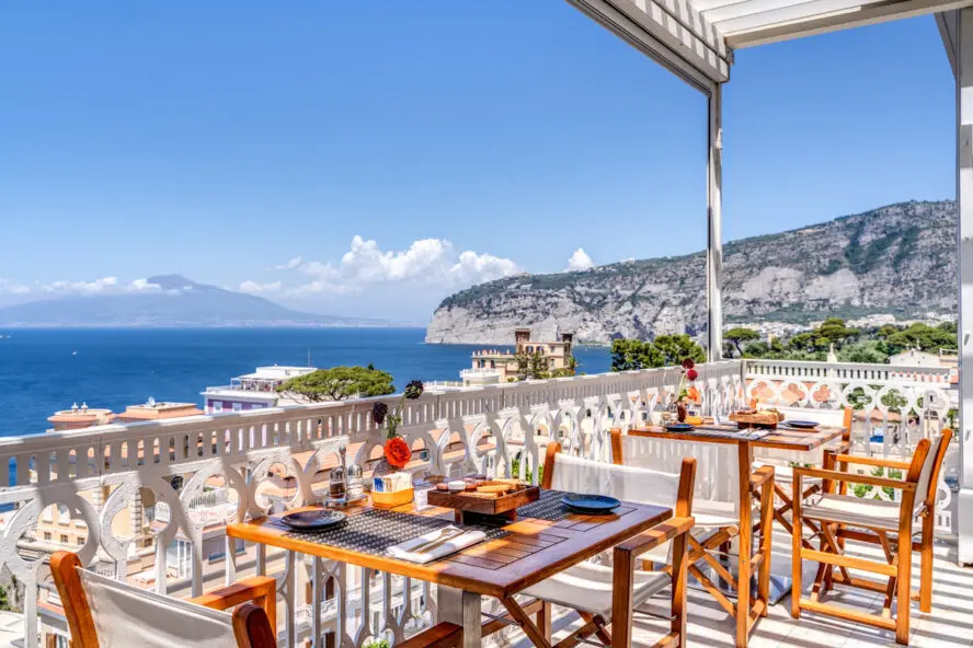Image of a gorgeous balcony terrace with a table for breakfasts overlooking the sea.
