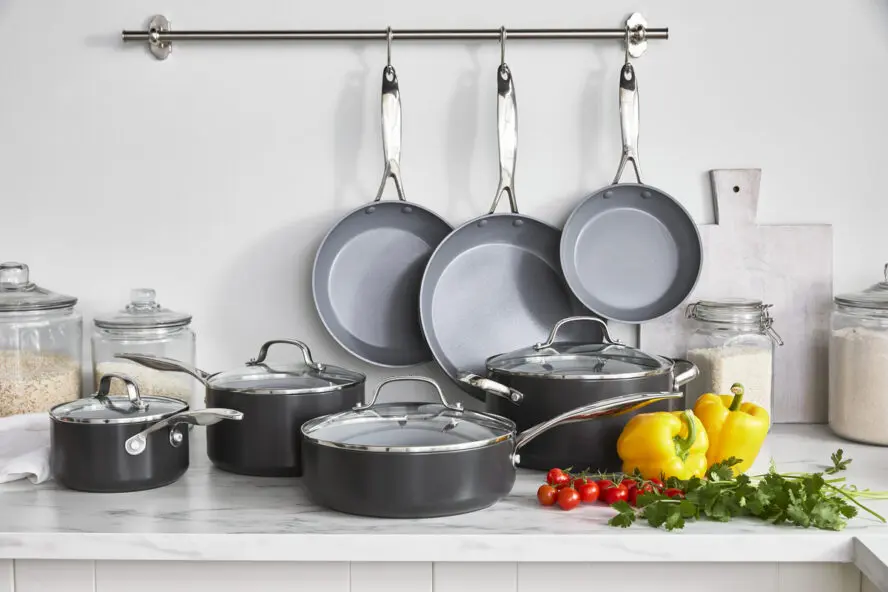 Image of the GreenPan Valencia Pro 11-piece set, displayed hanging and on a counter in a beautiful kitchen.