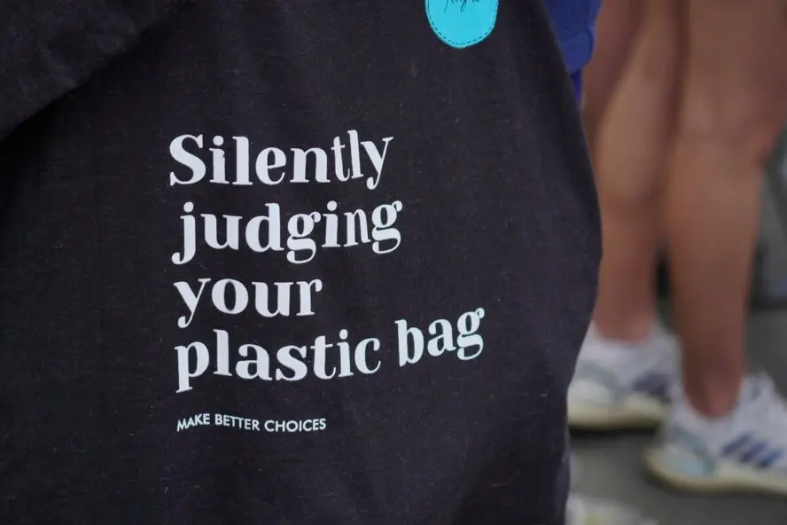 Image of a reusable tote bag that reads 'Silently judging your plastic bag.'