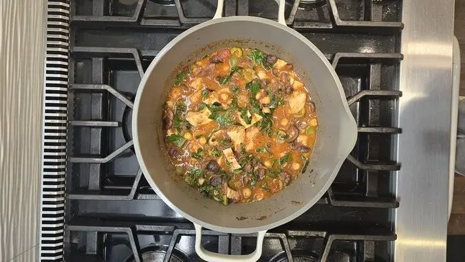 Image of the Our Place Perfect Pot full of a colorful bean broth on the stovetop.