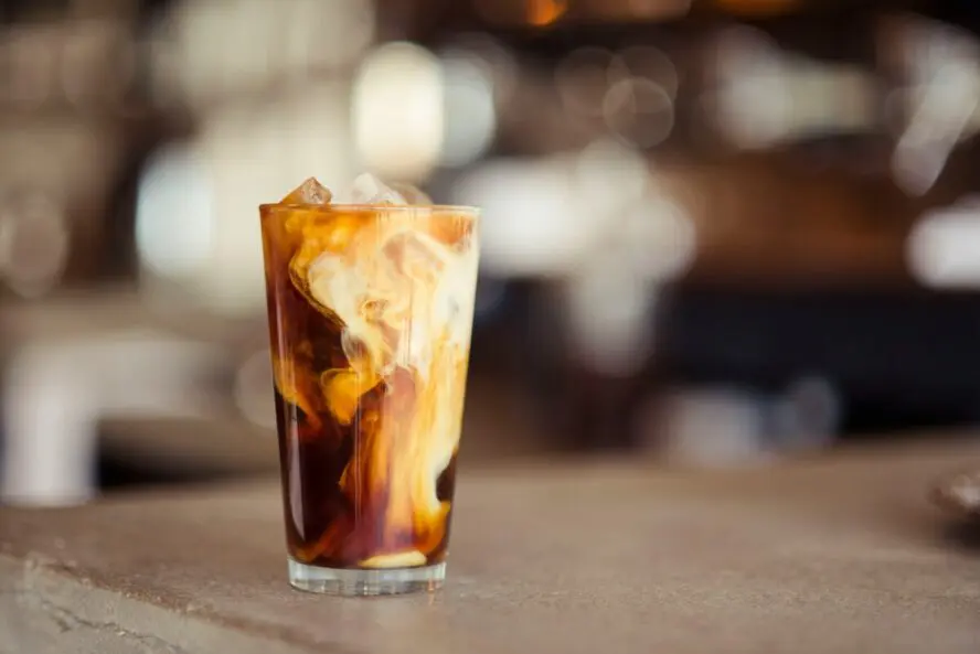 Image of an iced latte set on a table in a cafe.