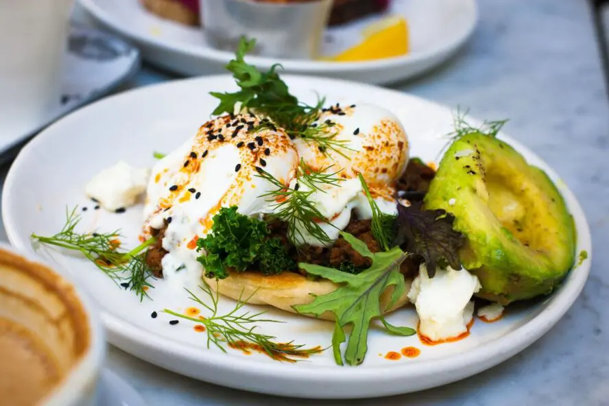 Image of a delicious brunch plate with poached eggs, avocado, and fresh greens.