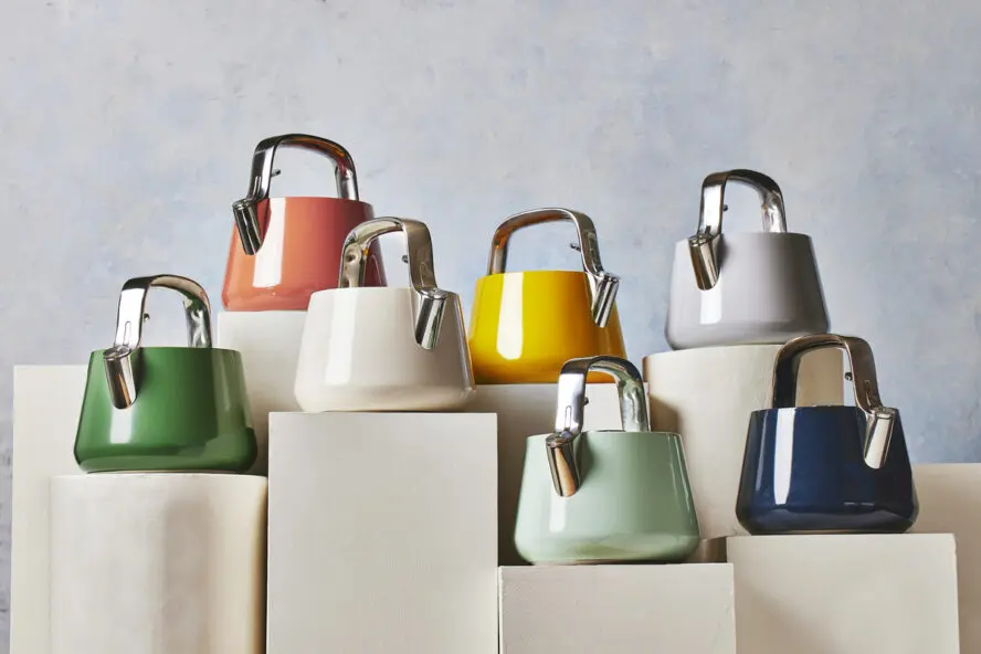Image of several Caraway tea kettles in a range of colors displayed artfully on pedestals.