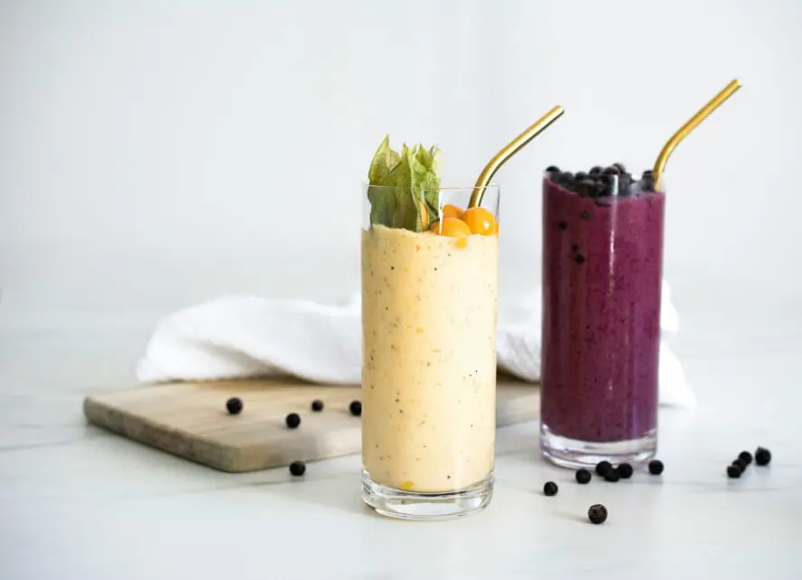 Image of two tall glasses full of smoothies made with Greek yogurt.