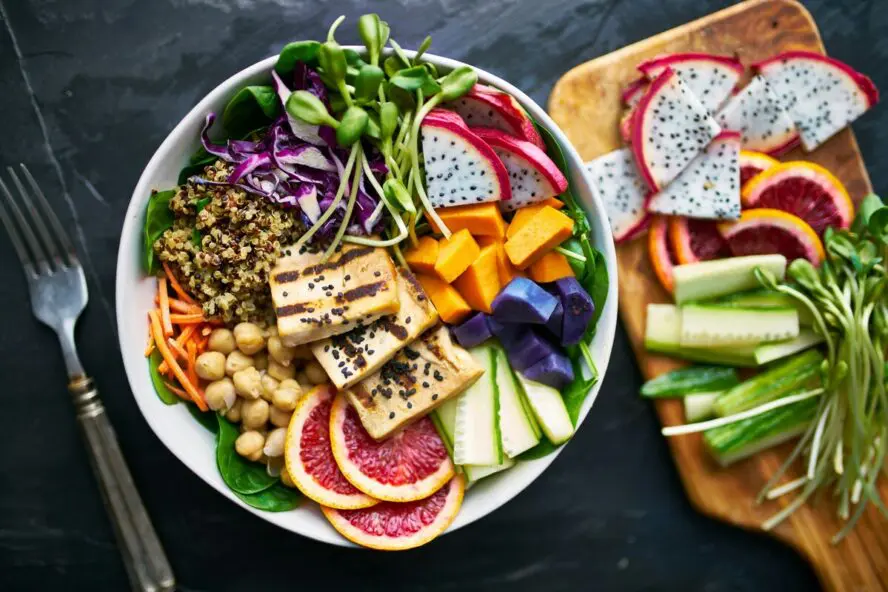 Image of a colorful bowl with grilled tofu, mango, various fruits, leafy greens, and high-fiber grains.