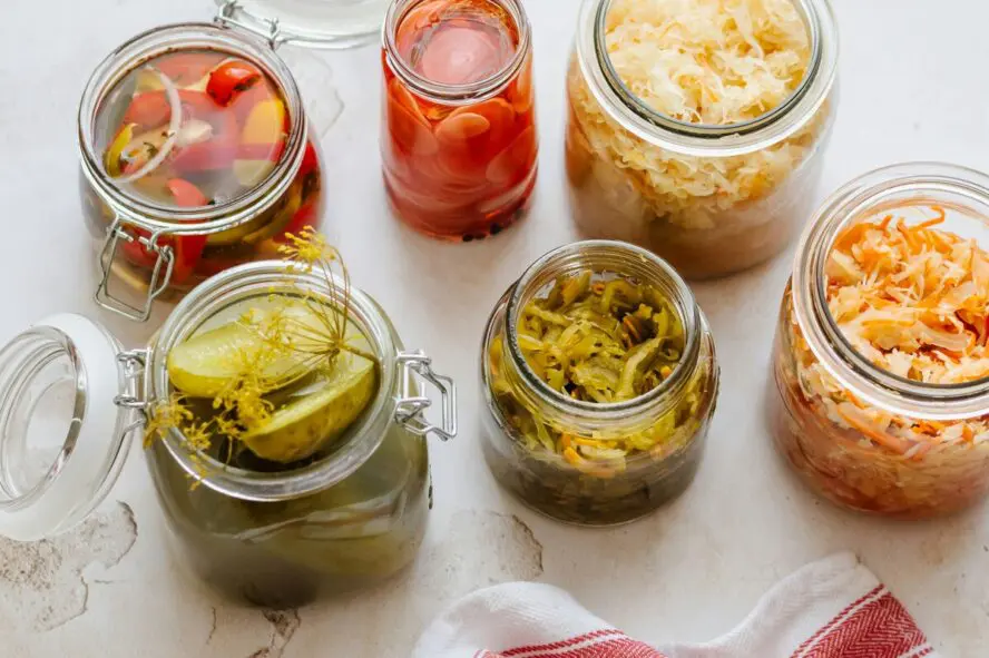 Image of several glass jars of pickled vegetables shot from above.