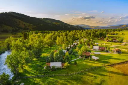 A drone shot of a sweeping Montana landscape, featuring the river and mountains of Camp Roosevelt at The Ranch at Rock Creek.