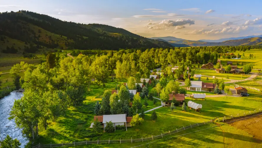 A drone shot of a sweeping Montana landscape, featuring the river and mountains of Camp Roosevelt at The Ranch at Rock Creek.