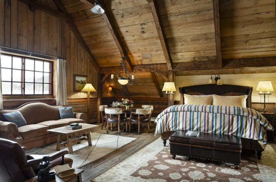 Image of a cozy and well-decorated cabin with a bed and seating.