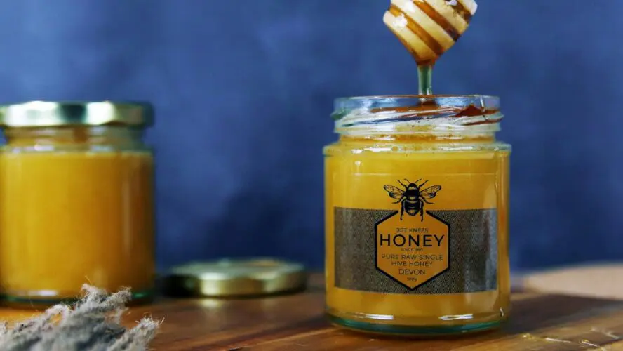 Image of two jars of raw honey, shown with a label from Devon.