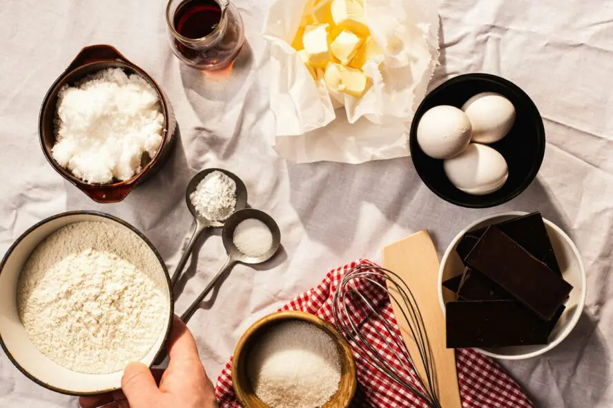 Image of a large table covered with baking supplies, including eggs, butter, and sucralose.