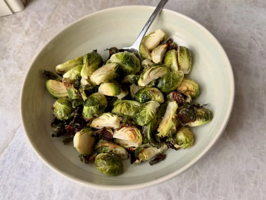 Image of a large and shallow bowl full of crispy air fryer Brussels sprouts.