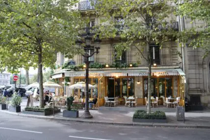 Image of a group of people sitting at an outdoor seating in a French restaurant.