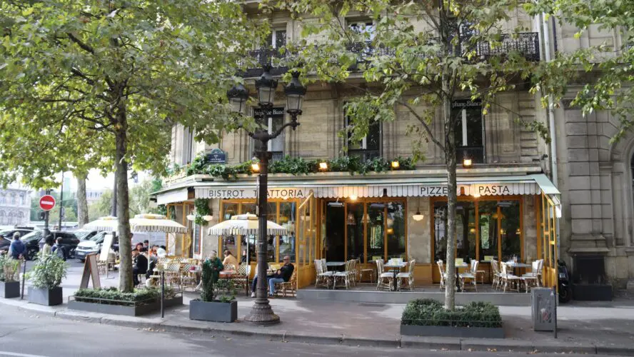 Image of a group of people sitting at an outdoor seating in a French restaurant.