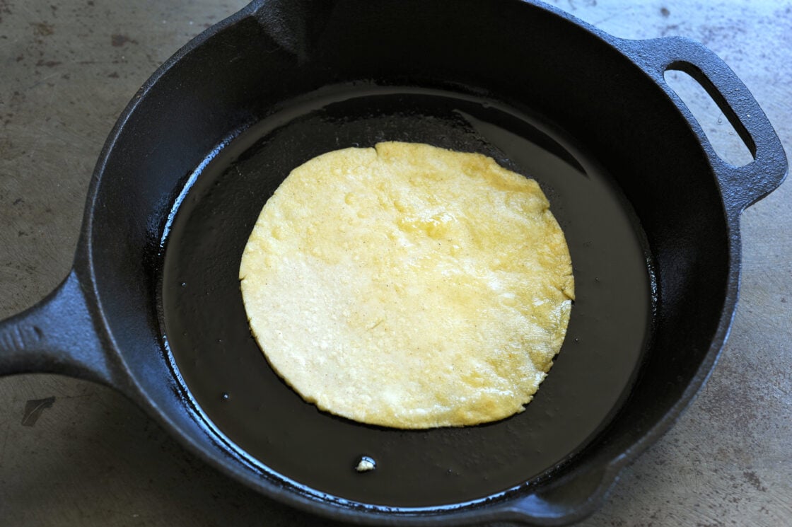 image of a homemade corn tortilla toasting up in a panhow to make tortillas