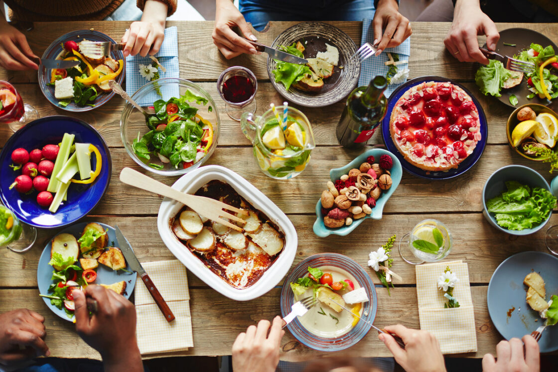 table of food with friends and wine. an elimination diet might be necessary if you have symptoms like persistent diarrhea, bloating, constipation, eczema and acne.