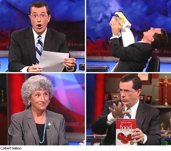 Stephen Colbert reacts dramatically while holding papers and a book on his talk show set