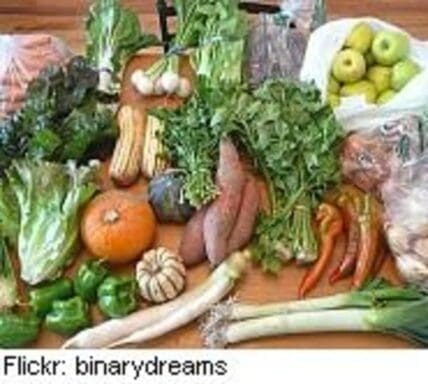 Assorted fresh organic vegetables and fruits arranged on a wooden surface