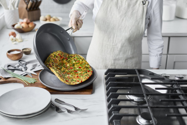 Person sliding frittata onto a plate out of a nonstick GreenPan cookware set via Organic Authority.