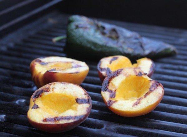 image of Grilled Peaches on grill with grilled poblano pepper in the background for use in vegan grilled peach summer salad.