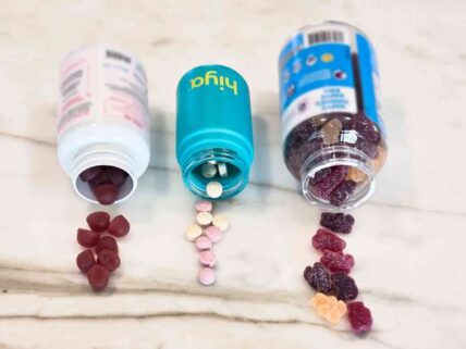 Image of three bottles of probiotics for kids, different brands in different colored bottles, with kids probiotic gummies and tablets spilling out