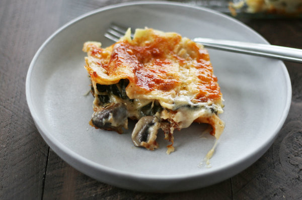 Image of a slice of vegetarian lasagna on a grey ceramic plate.