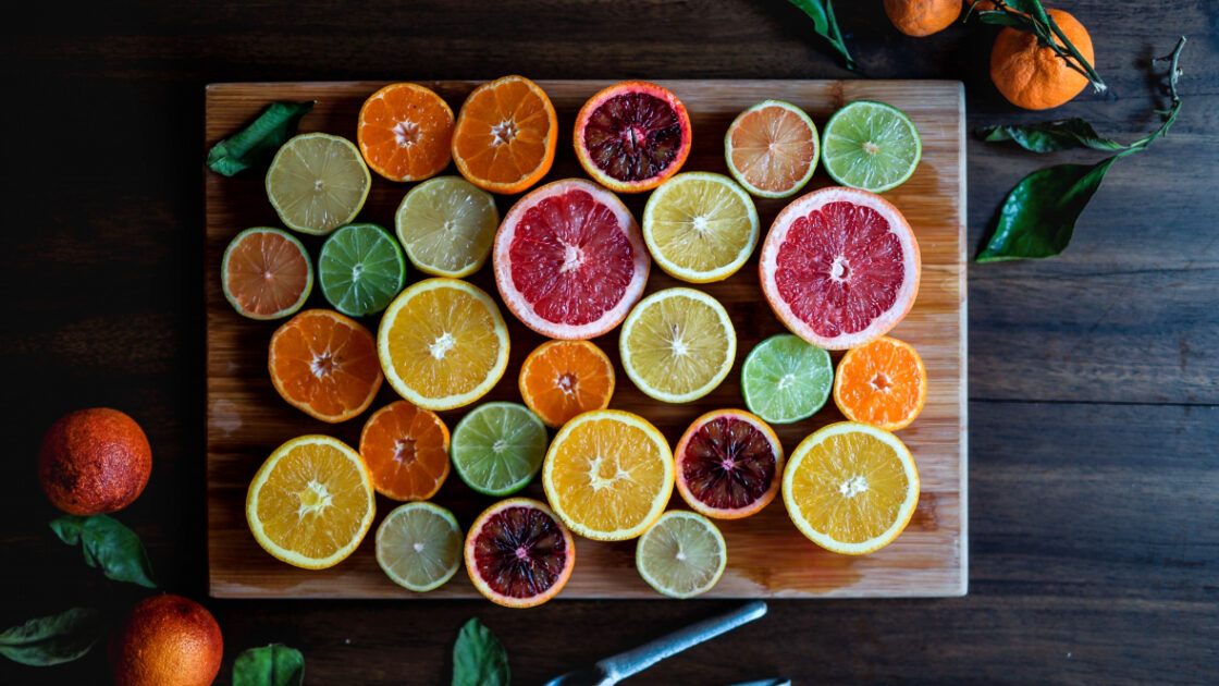 cut citrus, oranges, grapefruit, lime, lemons on cutting board
