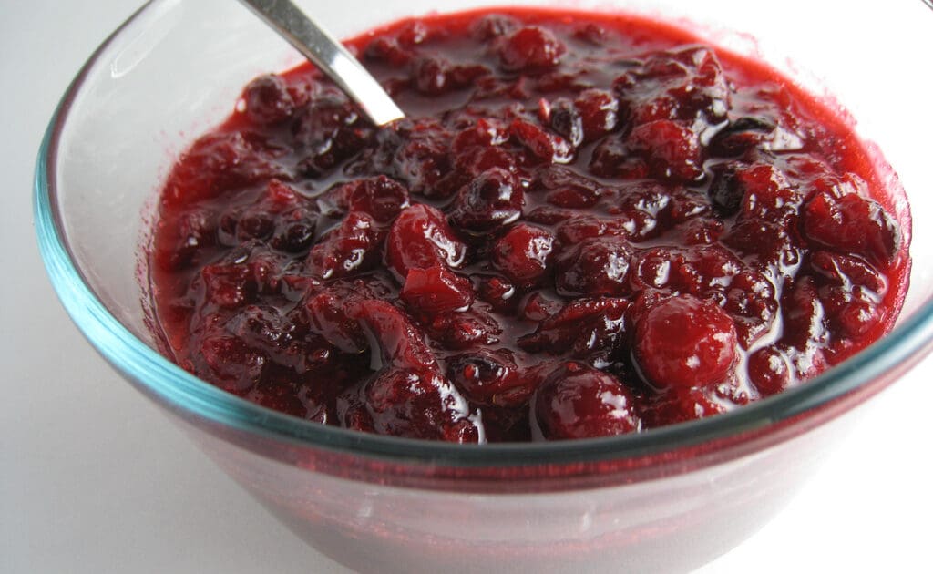 Image of cranberry sauce to accompany Thanksgiving dishes in a glass bowl.