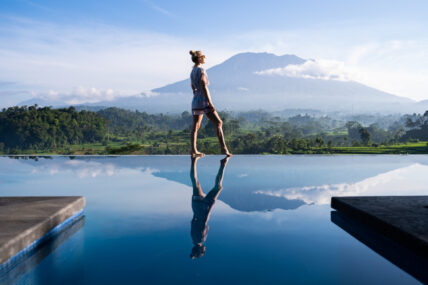 image of woman walking on the edge of an infinity pool. Follow these 5 steps to go beyond the ego and tap into your true self.