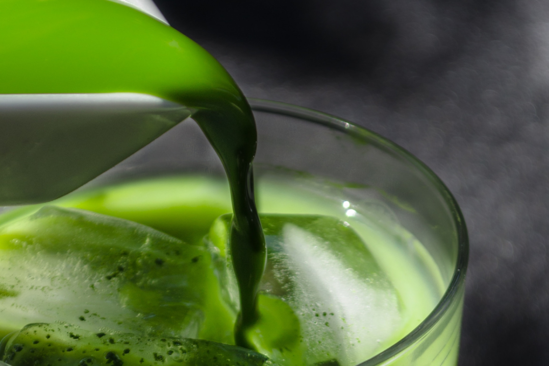 Image of deep green liquid chlorophyll poured from white vessel into cup with ice via Organic Authority. The benefits of liquid chlorophyll come mainly in part from its antioxidant activity and it is high in vitamins, minerals and other nutrients.