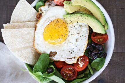 image of a mexican breakfast bowl topped with a fried egg. This hearty breakfast is super easy to make.