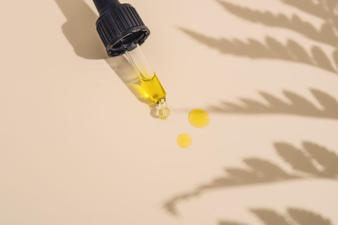 Image of Natural face serum oil in dropper on natural background with plant silhouettes via Organic Authority