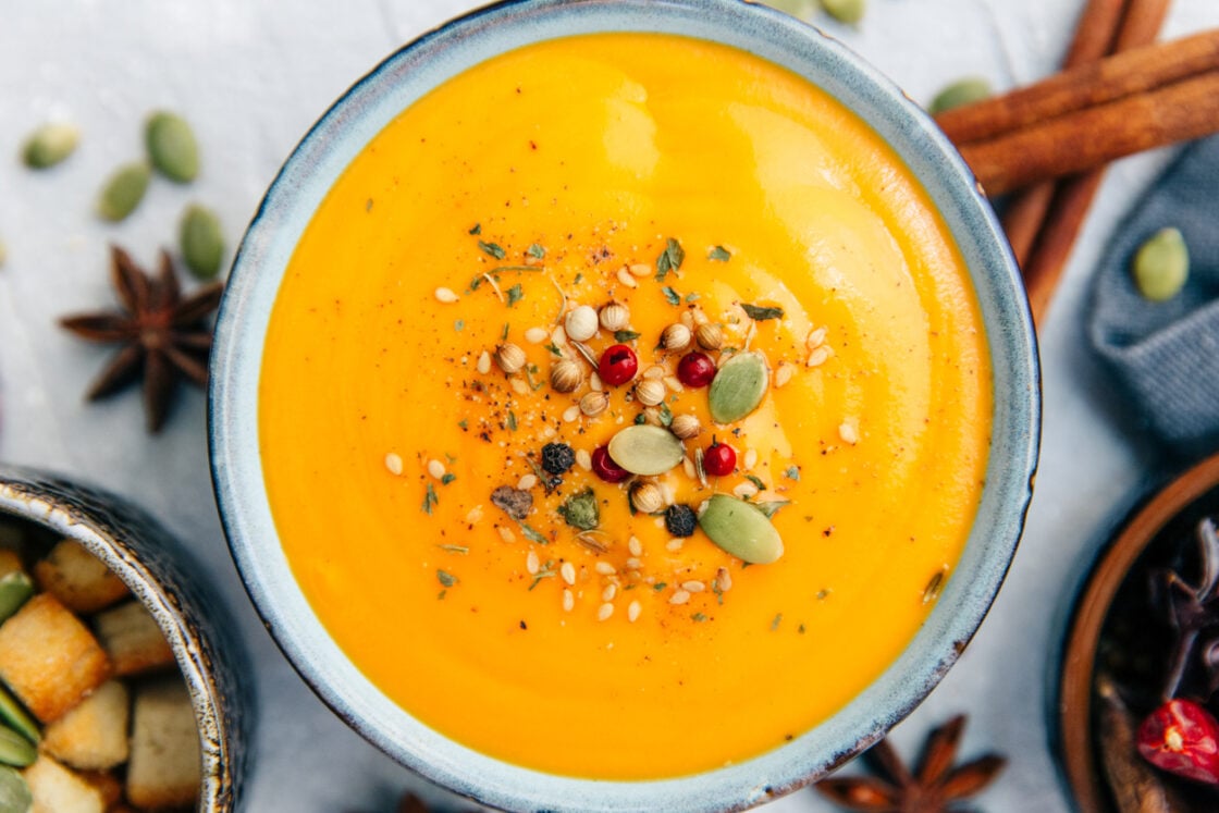 Image of heirloom pumkin squash soup topped with pepitas and pomegranite seeds and hemp seeds.
