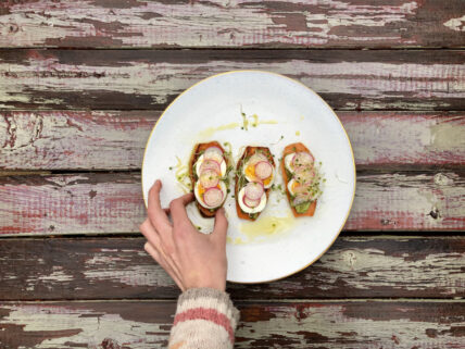 sweet potato toast with egg radish and a hand reaching in