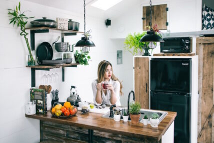 young asias woman in her kitchen sipping tea
