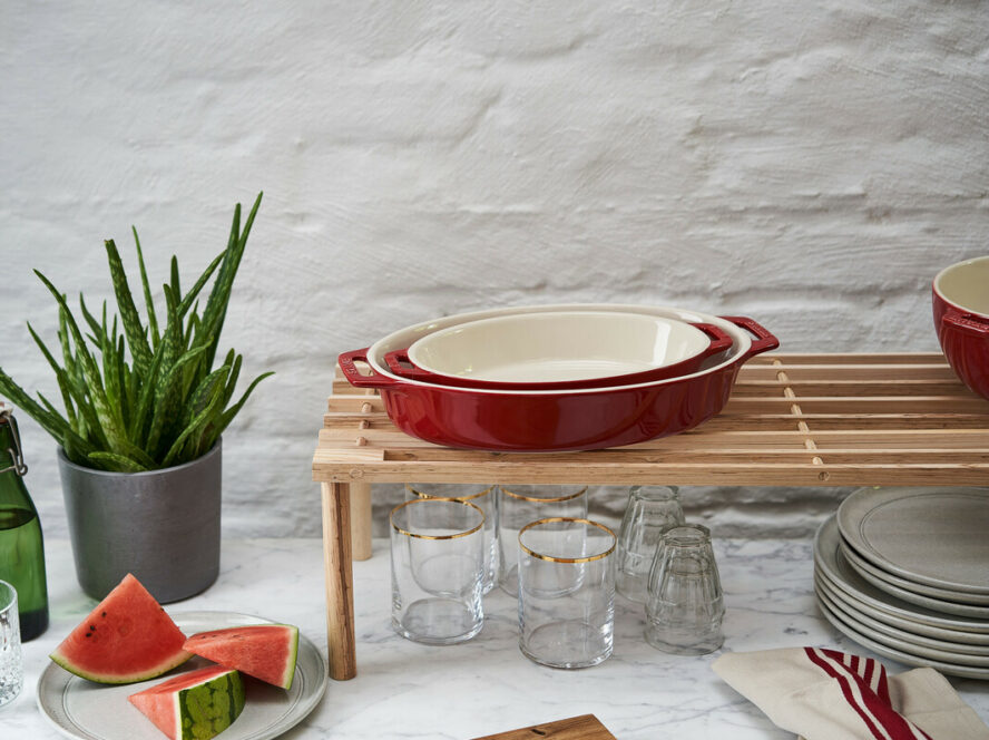 Image of the Staub oval baking dish set in a bright cherry red color, with two dishes nested inside each other.