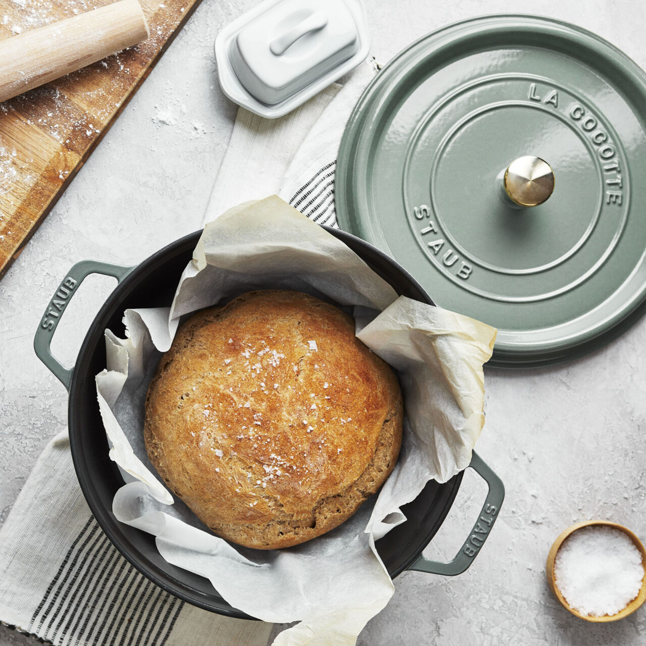 Image of the Staub Round Dutch Oven in Eucalyptus with a loaf of sourdough bread.