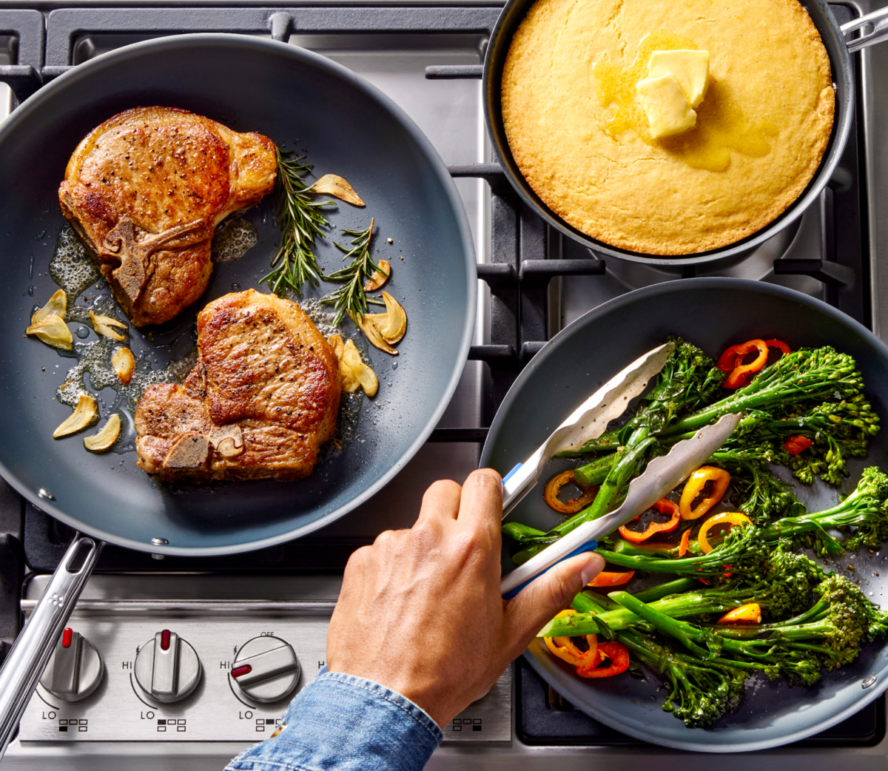 Image of three Misen Carbon Nonstick pans on a stovetop in three different sizes, all being used to cook different foods.