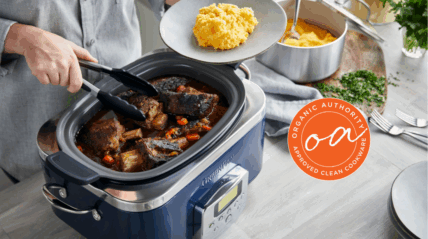 Image of the GreenPan Elite Slow Cooker in Oxford Blue, with a person using tongs to plate up slow cooked meat on top of mash directly from the cooker.