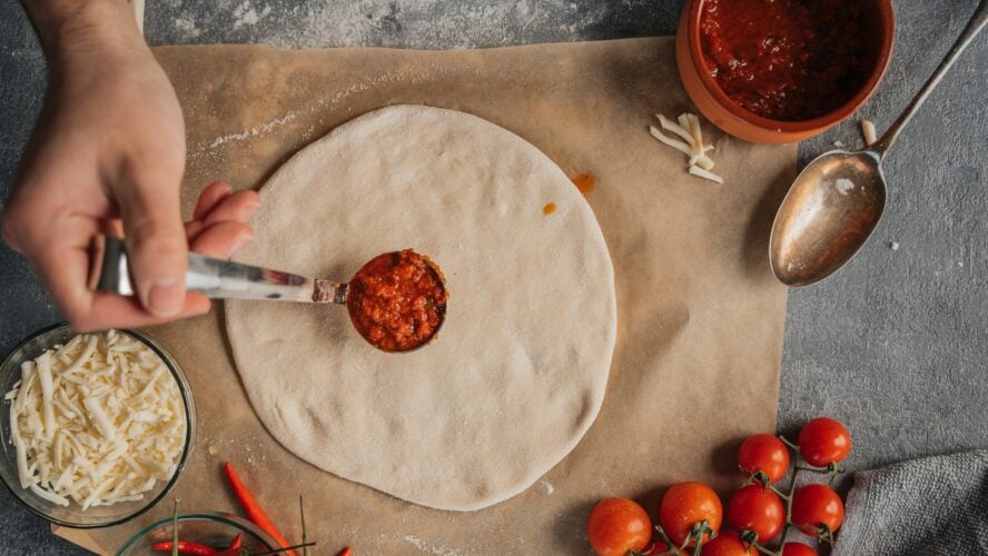 image of organic pizza dough with a dollop of marinara sauce