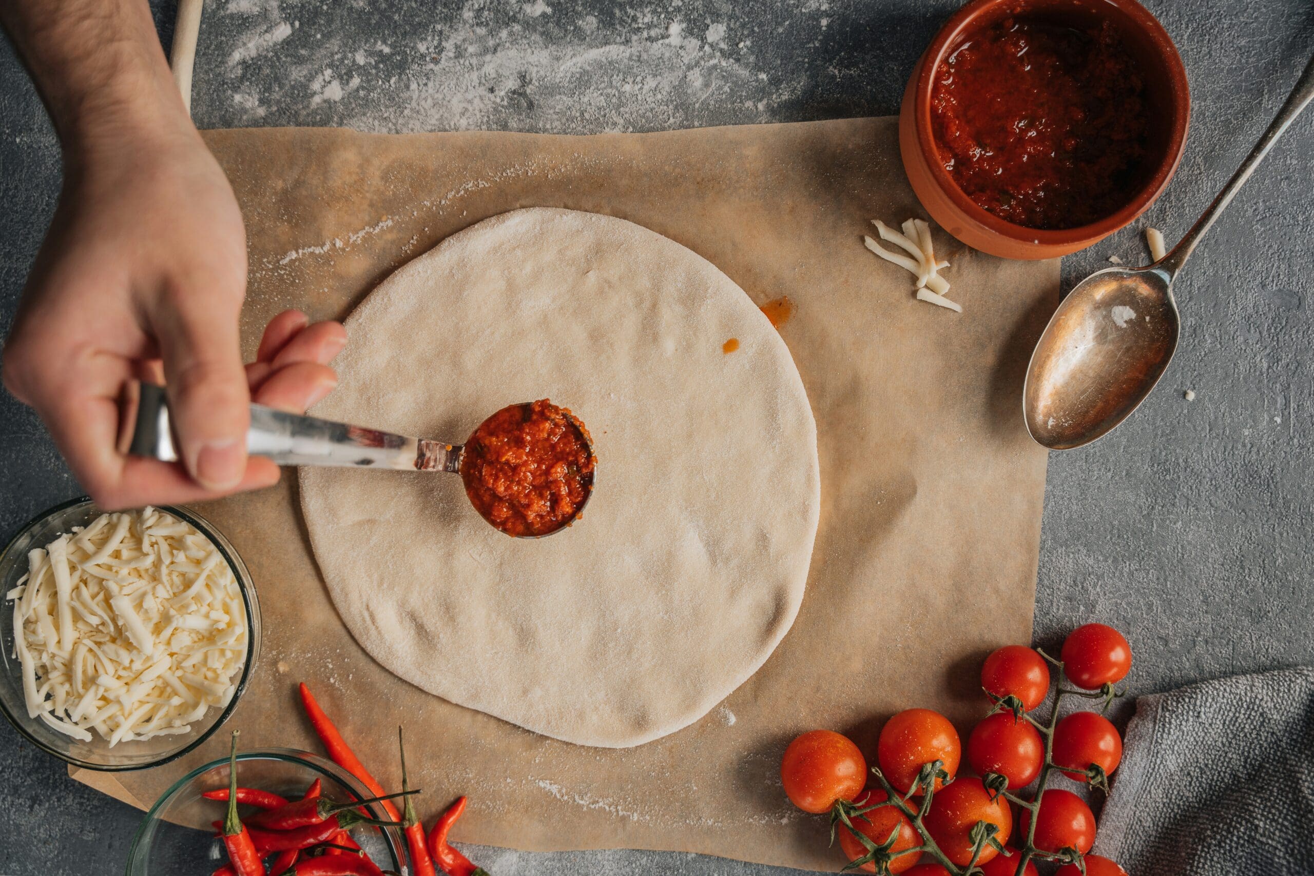 image of organic pizza dough with a dollop of marinara sauce
