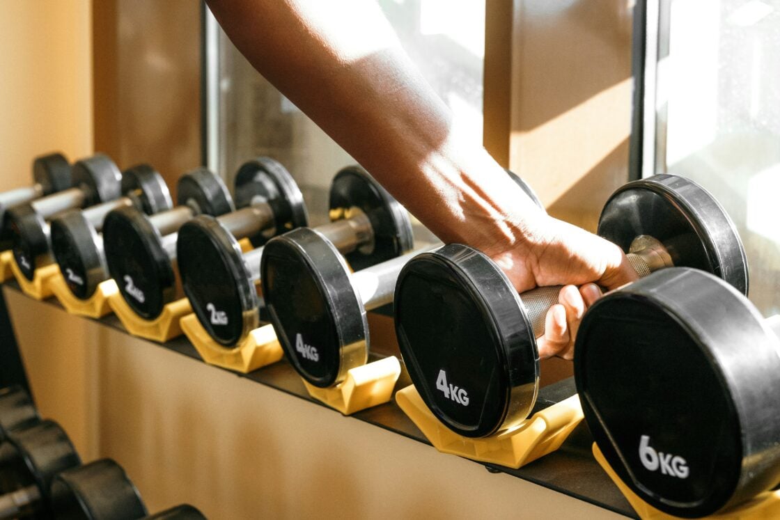 image of a hand reaching for a dumbell for working out